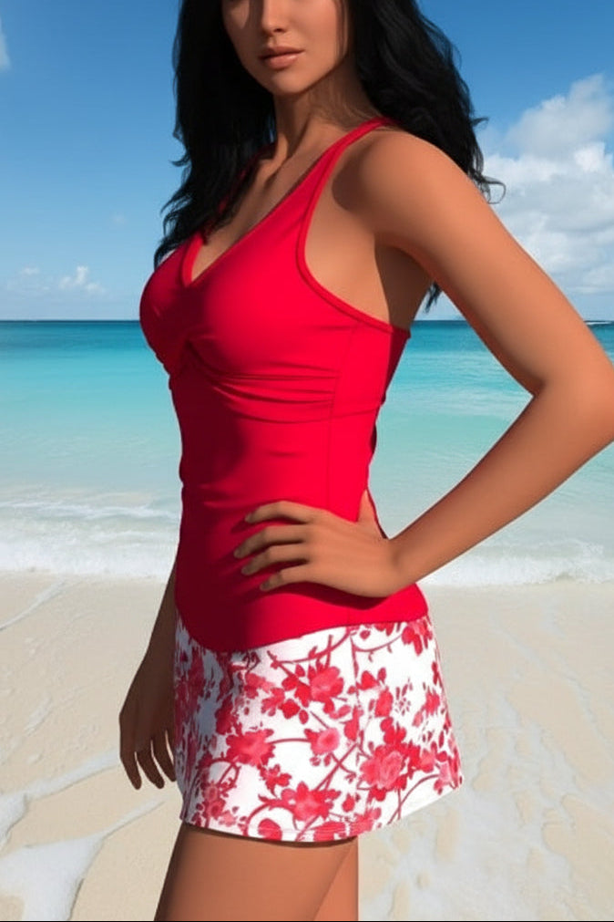 Woman wearing a red tank top and floral skirt on a beach